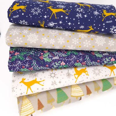 A christmas fat quarter bundle of 5 christmas designs including reindeer, snowflakes and holly in a navy, white, silver and gold colourway.