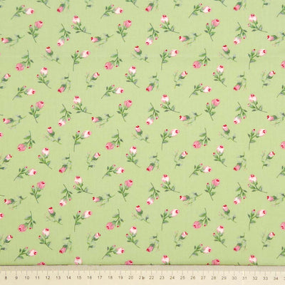 Floral pattern with pink flowers and green leaves on a sage green cotton poplin with a cm ruler