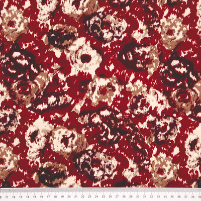 Close-up of a red floral patterned fabric with a cm ruler