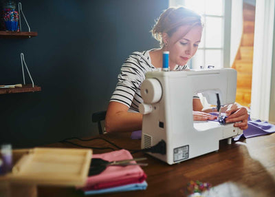 A lady concentrating on her sewing machine