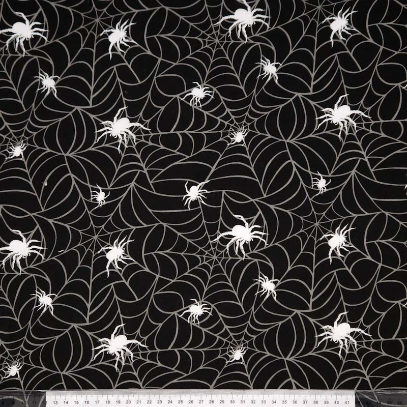 Black fabric with white spider webs and spiders pattern