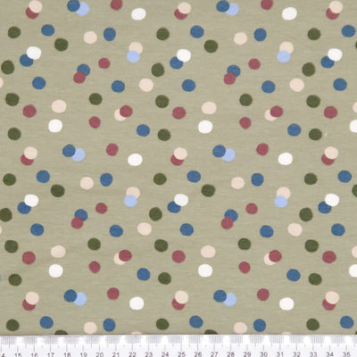 Dots printed on an olive green cotton jersey fabric with a cm ruler