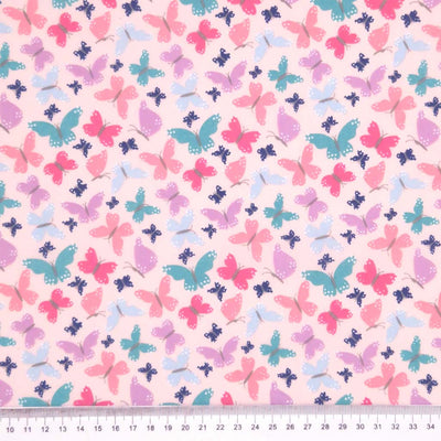 Butterflies printed on a pink polycotton fabric with a cm ruler