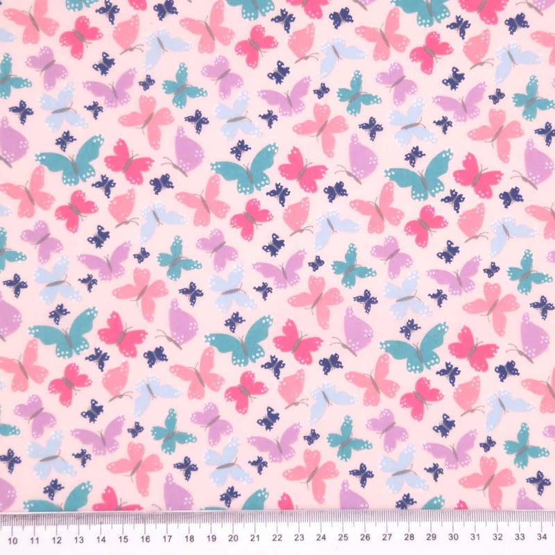 Butterflies printed on a pink polycotton fabric with a cm ruler