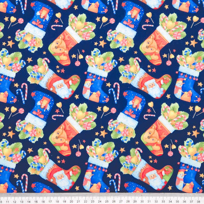 Pattern of Christmas stockings with Santa Claus on a blue background, with a ruler at the bottom for scale.