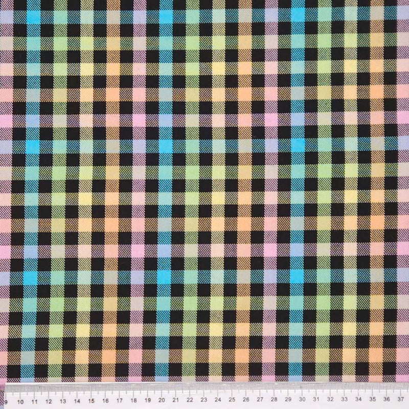 Multicolored plaid pattern fabric with a ruler at the bottom for scale.