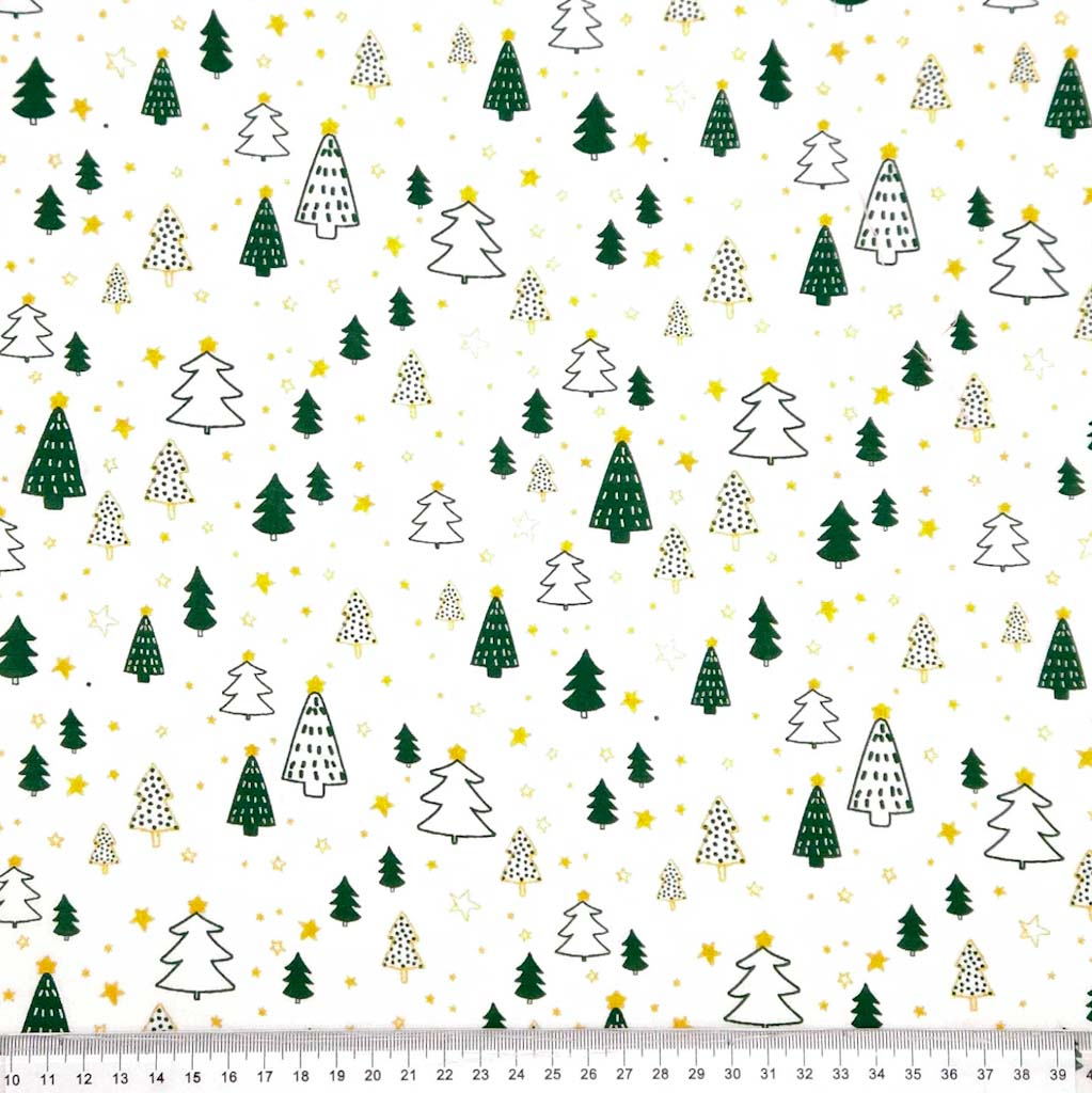 Pattern of Christmas trees and stars on a white cotton fabric with a ruler at the bottom