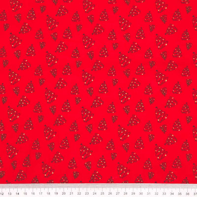 Red cotton fabric with small black and white christmas trees with a ruler