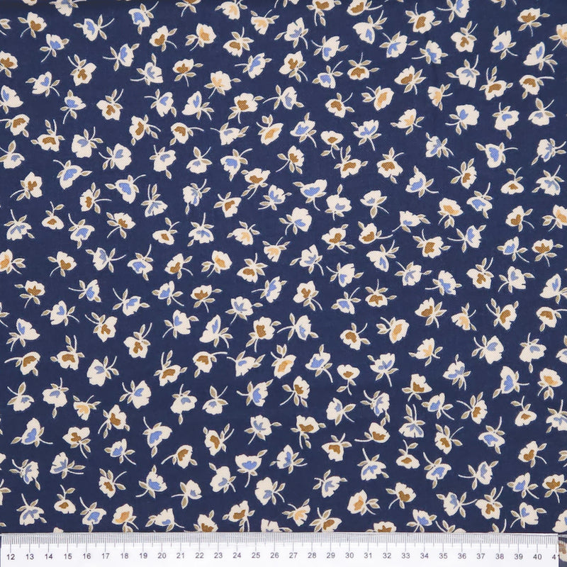 Floral patterned fabric with small flowers on a blue background, measured against a ruler.