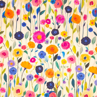 A floral viscose featuring delicately painted multicoloured wildflowers on a light cream dressmaking fabric