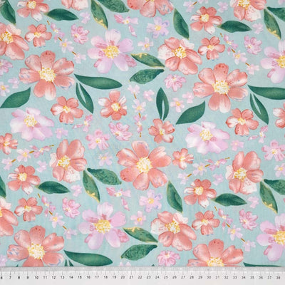 Pretty coral coloured flowers are printed on a mint coloured woven viscose fabric with a cm ruler