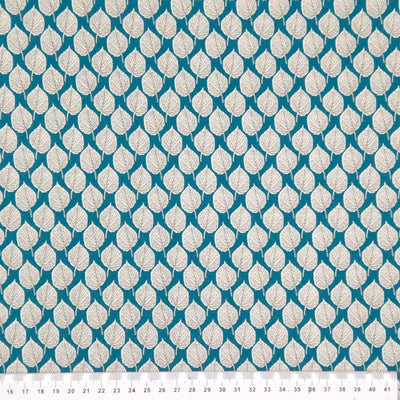 Leaves printed on a teal viscose dressmaking fabric with a cm ruler