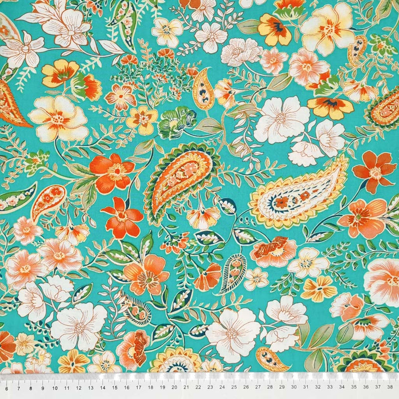 Summer vibes with orange florals and paisley teardrops are printed on an aqua woven viscose fabric with a cm ruler
