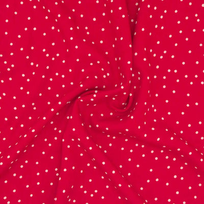 Small scattered white spots printed on red viscose fabric