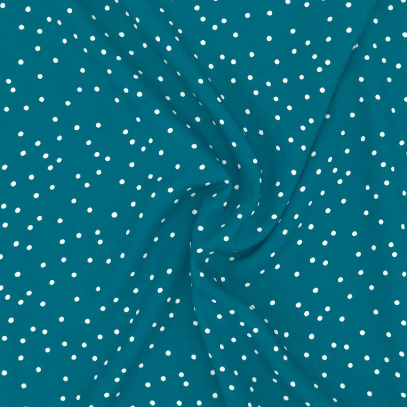 Small scattered white spots printed on teal viscose fabric