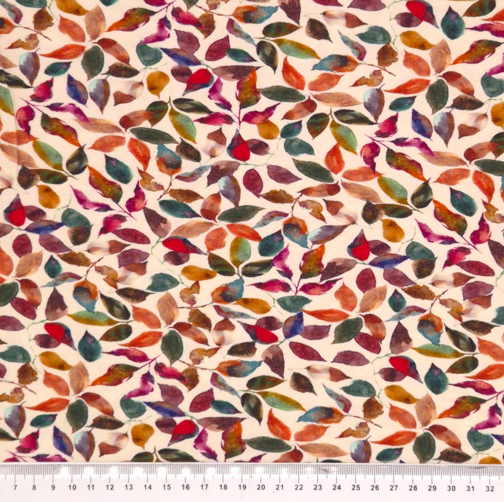 Autumnal leaves printed on a beige viscose jersey fabric with a cm ruler