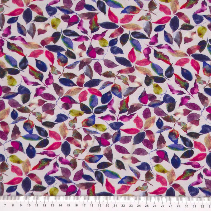 Berry coloured leaves printed on a viscose jersey fabric with a cm ruler