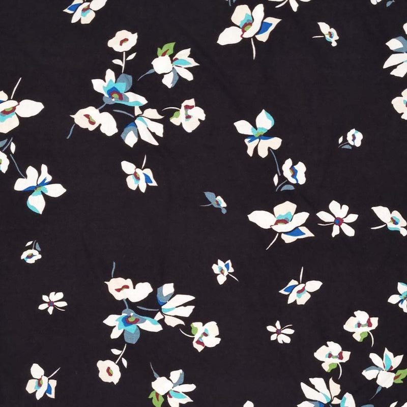 A white floral with sky blue detail is printed on a black viscose fabric