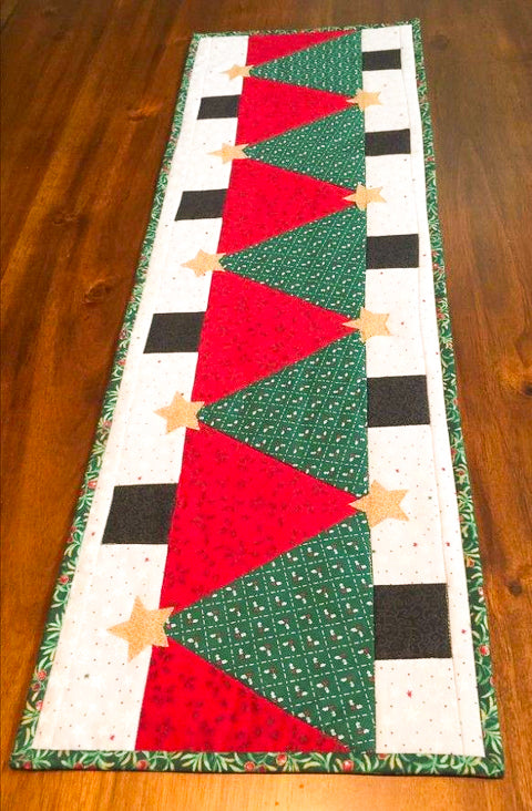 Quilted table runner with Christmas tree pattern on a wooden floor