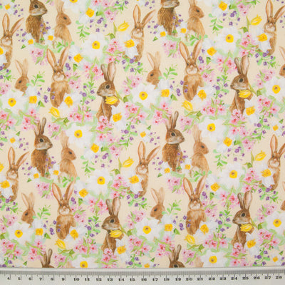 Inquisitive little bunny rabbits hiding amongst daffodils are printed on a fat quarter of cotton fabric with a ruler at the bottom for size perspective