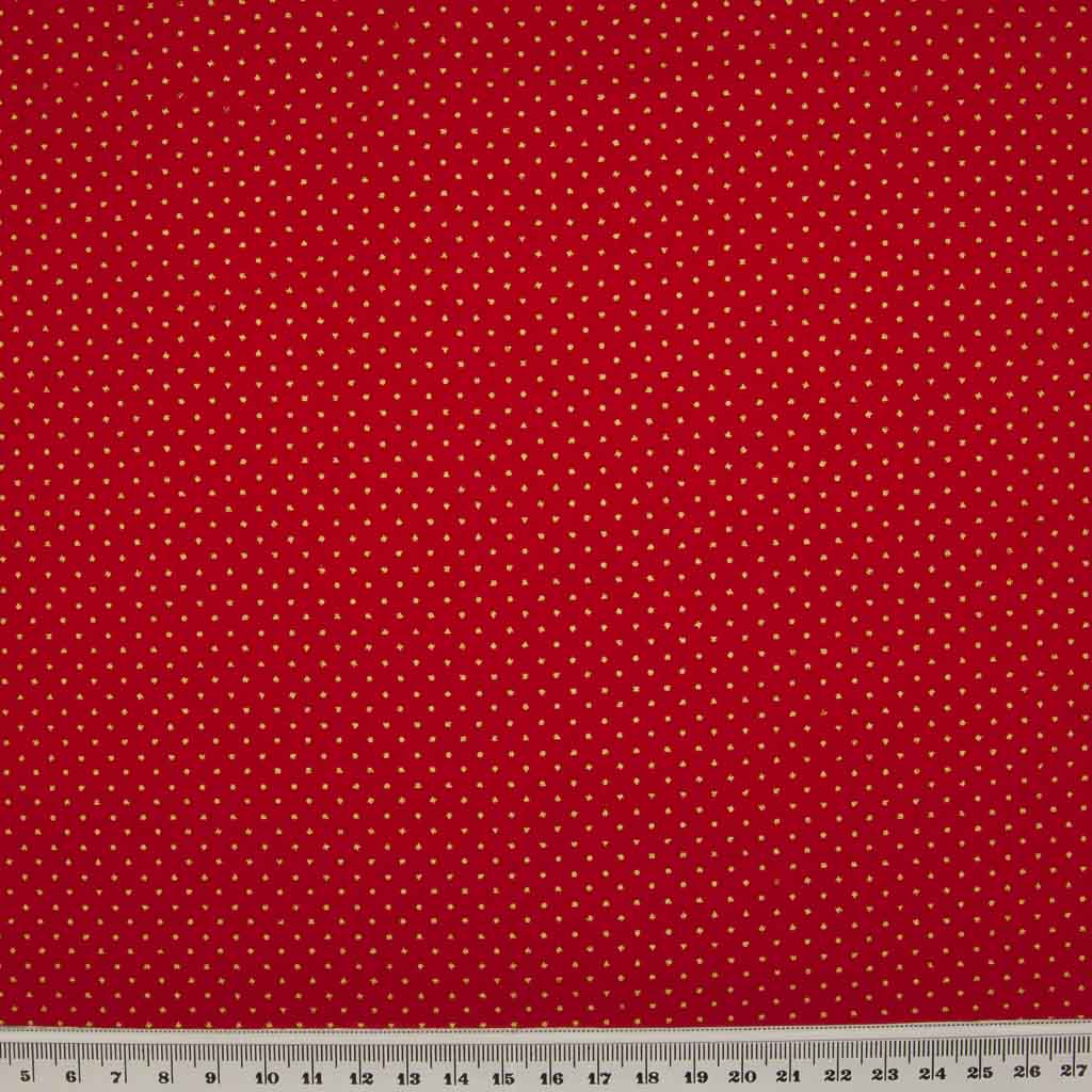 2mm gold lacquer pin spots are printed on a red cotton christmas fabric with a cm ruler at the bottom