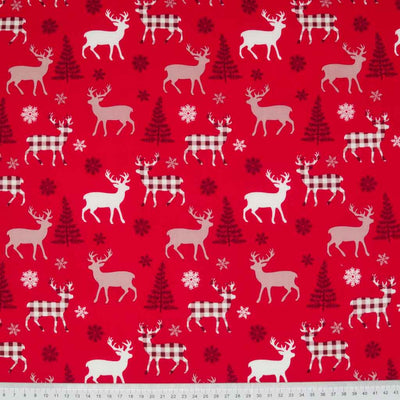 Ivory and red check reindeer on a 100% cotton, red fabric. with a cm ruler at the bottom