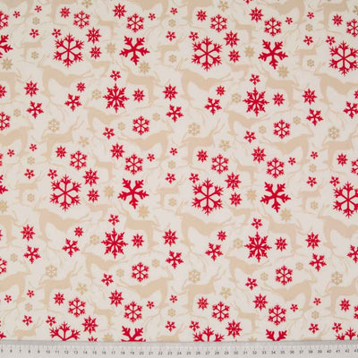Light beige reindeer, deep red stars and gold glitter stars are printed on an ivory, 100% cotton fabric with a cm ruler at the bottom