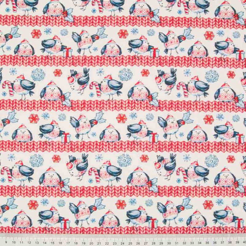A scandi style print of jolly robins and snowflakes in a white and red colourway printed on 100% cotton fabric with a cm ruler at the bottom