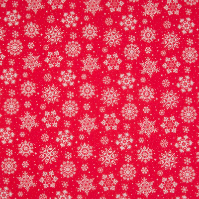 White intricate snowflakes printed on a red christmas polycotton fabric