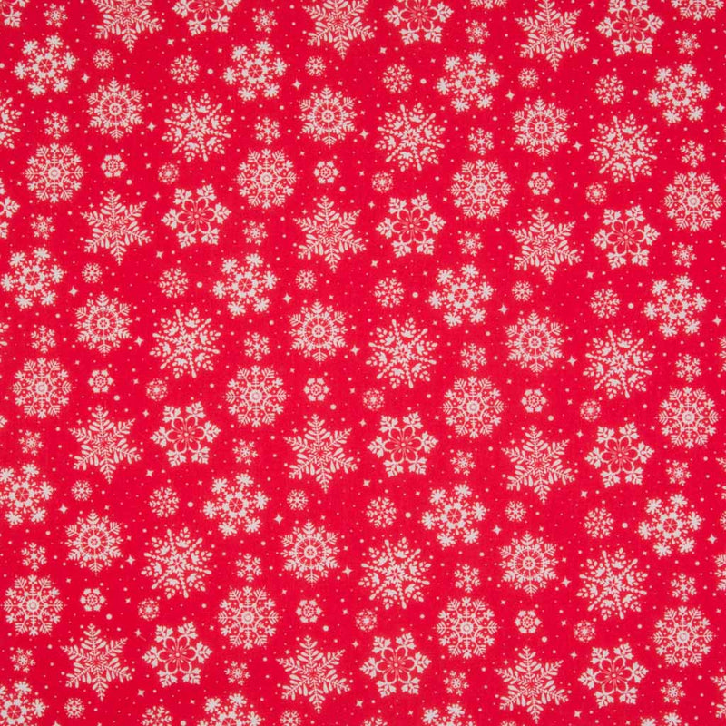 White intricate snowflakes printed on a red christmas polycotton fabric