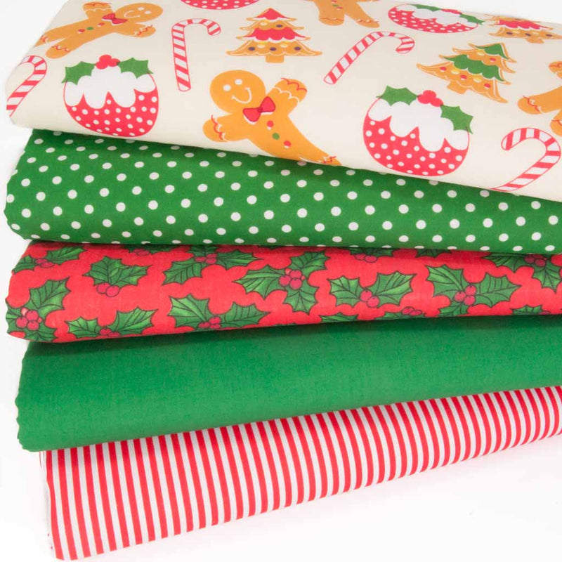 A fat quarter bundle of christmas polycotton fabrics with gingerbread men and holly