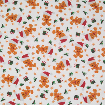 Gingerbread men, gifts and green holly printed on a white polycotton fabric