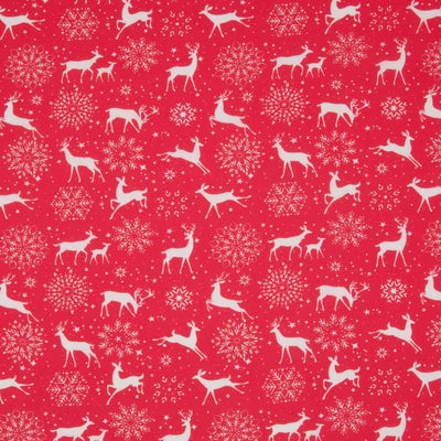 White reindeer and snowflakes are printed on a red, christmas polycotton fabric