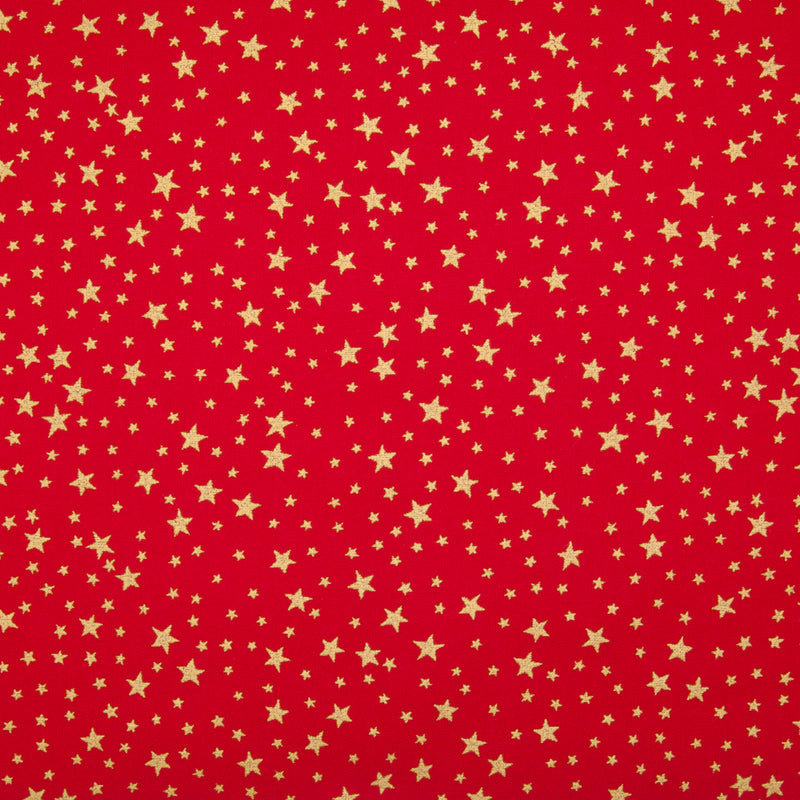 A red christmas cotton fabric featuring small metallic gold stars in a tossed pattern