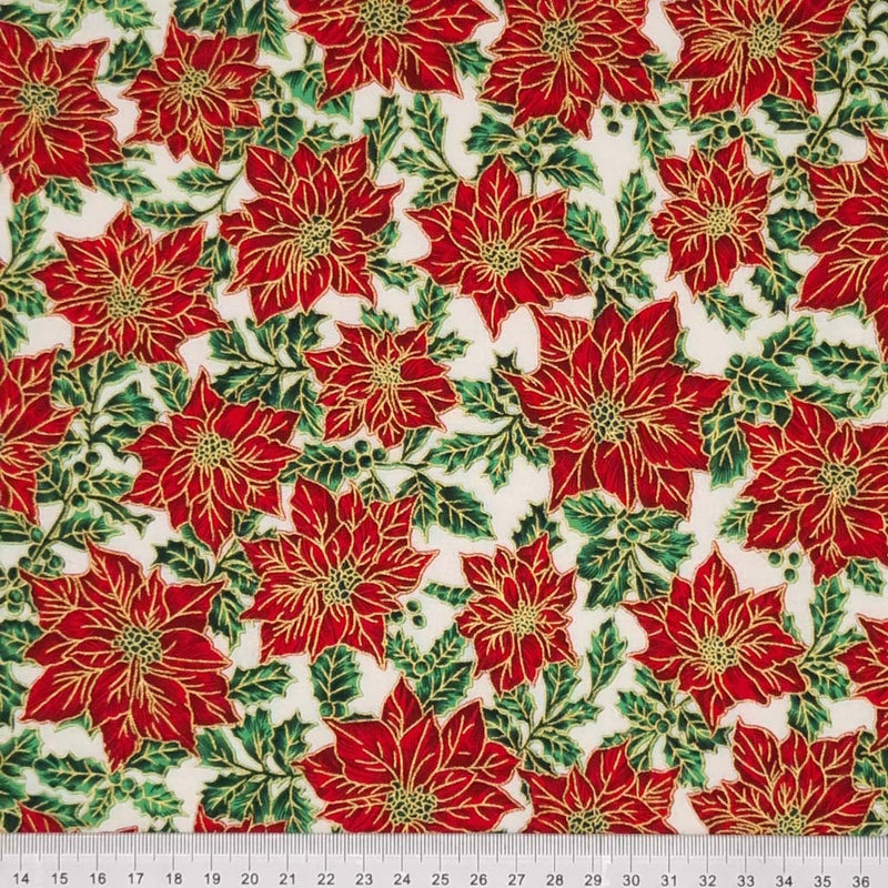 Red with a metallic gold edge Christmas poinsettia flowers and leaves are printed on an ivory 100% quality cotton fabric by Rose & Hubble with ruler