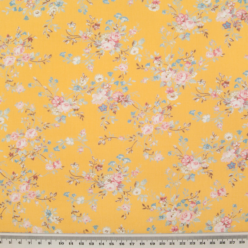 A beautiful, delicate floral print by Rose and Hubble printed on lemon yellow cotton poplin fabric with ruler for size perspective