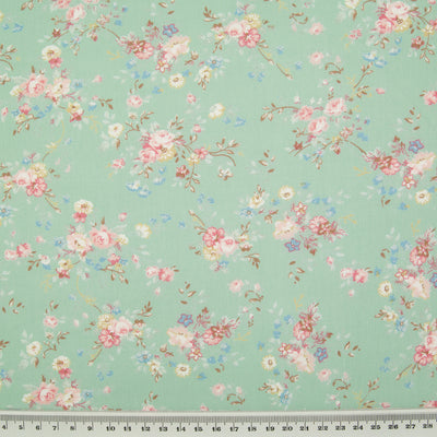 A beautiful, delicate floral print by Rose and Hubble printed on meadow green cotton poplin fabric with ruler for size perspective