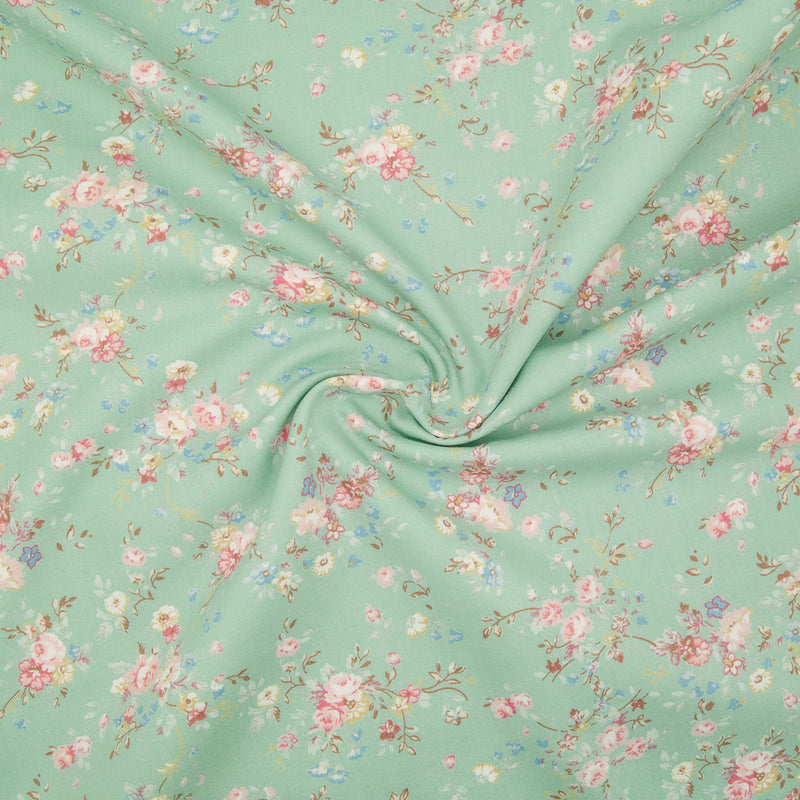 A beautiful, delicate floral print by Rose and Hubble printed on meadow green cotton poplin fabric with swirl for drape perspective