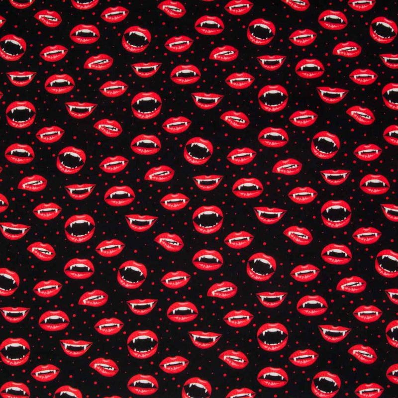 Vampire mouths with fang teeth and bright red lips are printed on a black, 100% cotton halloween fabric