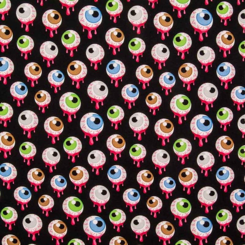 Green, brown and blue eyeballs dripping with pink goo are printed on a black, 100% cotton, halloween fabric