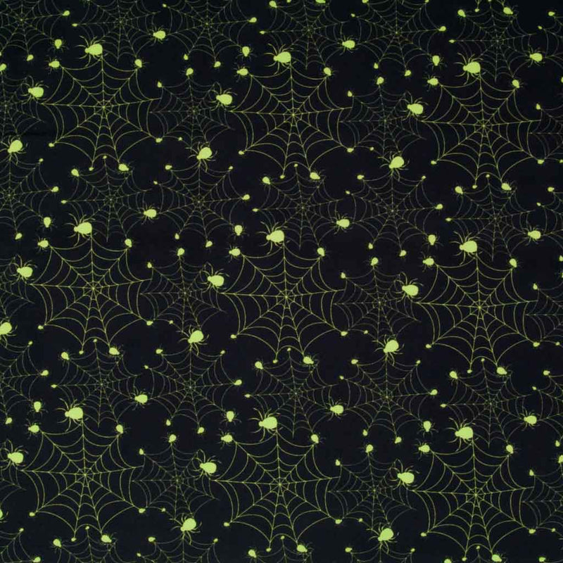 Bright neon green spiders on cobwebs are printed on a black, 100% cotton halloween fabric