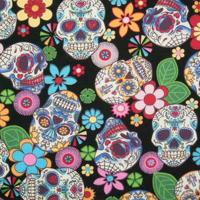 A Rose & Hubble cotton fabric with bright and colourful skulls and flowers printed on a black background
