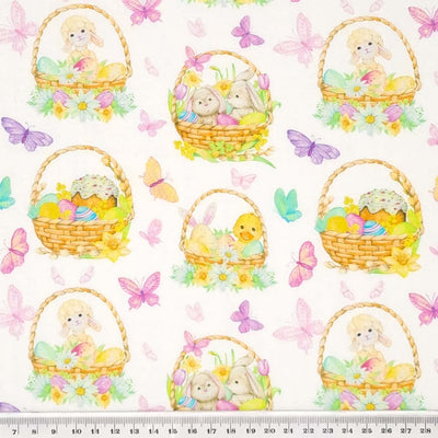 Rabbits, lambs and chicks in easter baskets are printed on a white cotton fabric with a cm ruler
