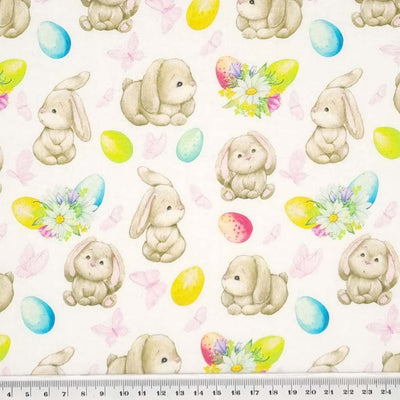 Cute easter bunnies with colourful easter eggs are printed on a quality white 100% cotton fabric with a cm ruler