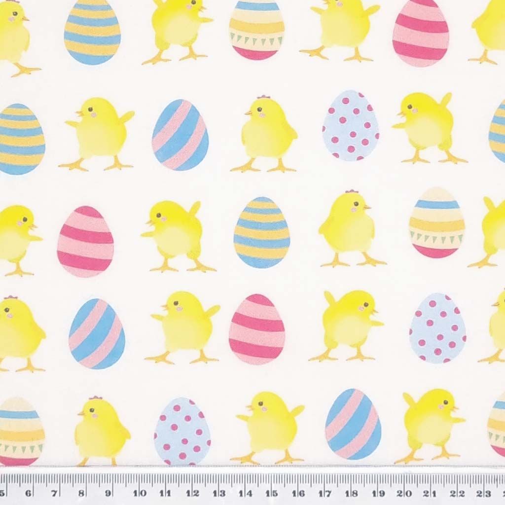 Easter eggs and chicks are printed on an ivory cotton fabric by Rose & Hubble with a cm ruler
