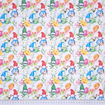 Colourful easter eggs and gnomes printed on a white cotton fabric by Rose & Hubble with a cm ruler at the bottom