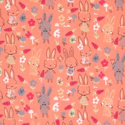 Sweet easter rabbits are printed on a salmon pink polycotton fabric