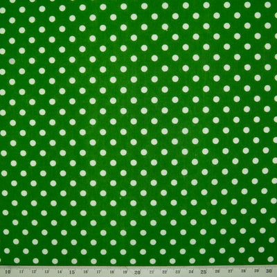 White spots printed on a green polycotton fabric