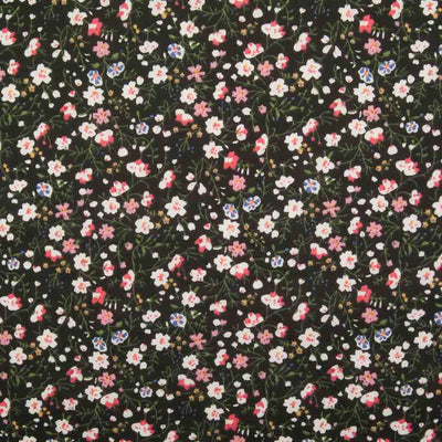 White, pink and blue ditsy flowers are printed on a black polycotton fabric