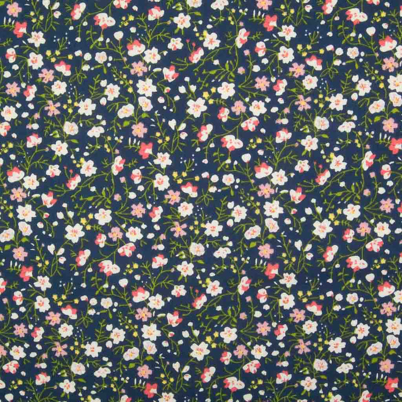 White, pink and blue ditsy flowers are printed on a navy  polycotton fabric